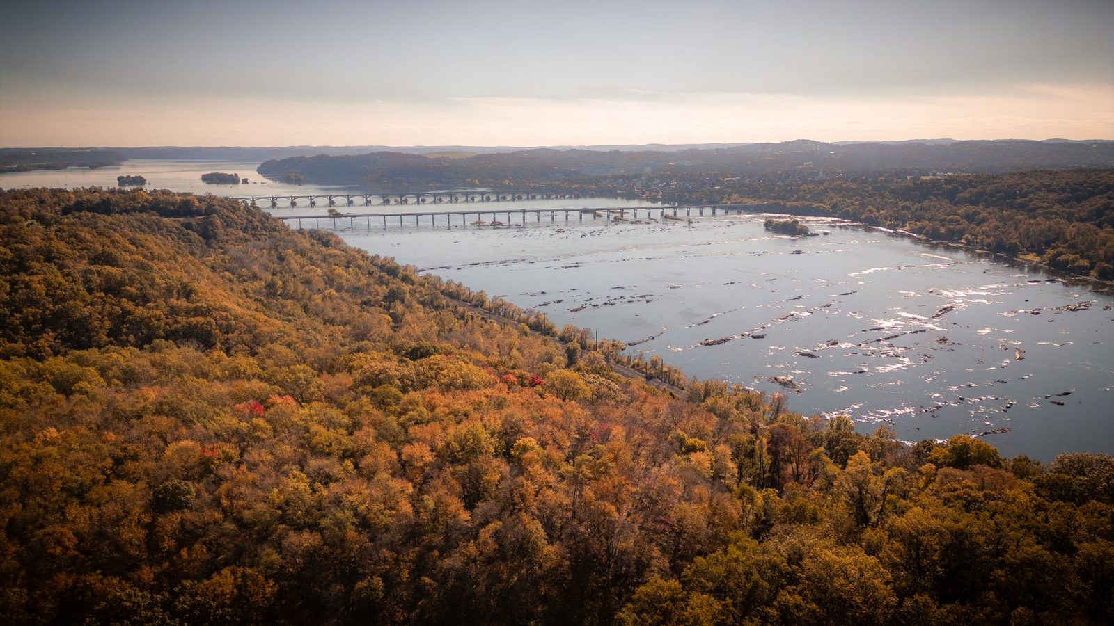 Autumn colour along the lower Susquehanna River in Pennsylvania, with a long road bridge crossing between wooded ridges